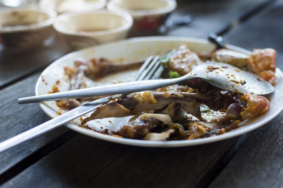 A plate with silverware and food scraps