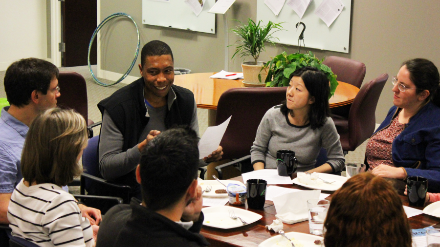 A group of SESYNC postdocs seated at a table having a discussion