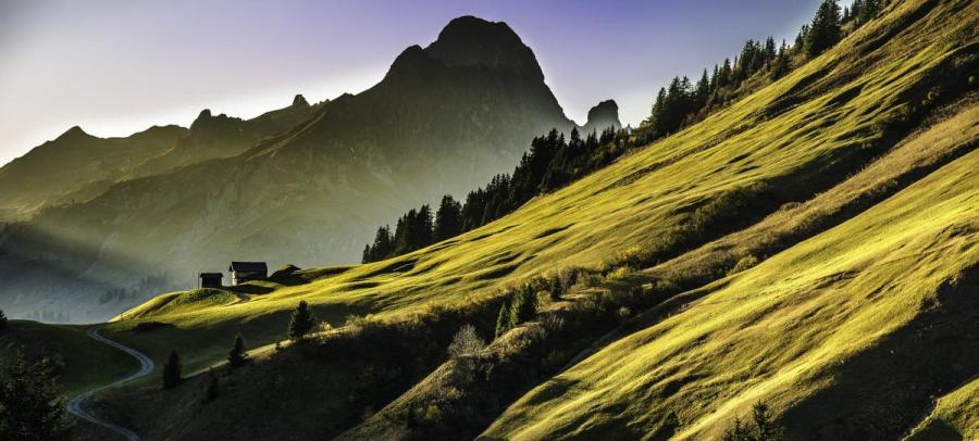 A landscape view of a mountainside with another mountain in the background